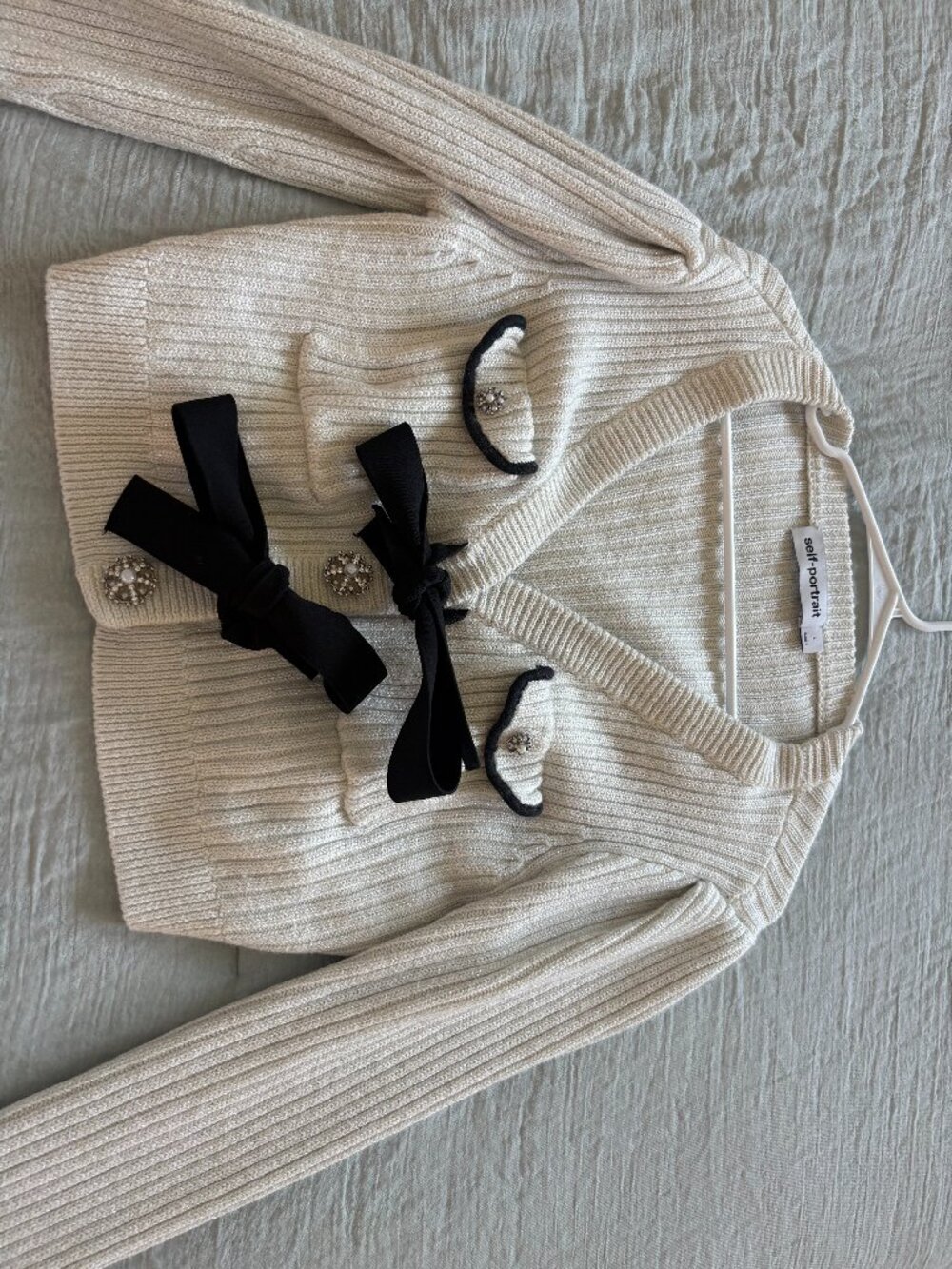 Self-Portrait ribbed knit cardigan, characterized by its decorative black ties a